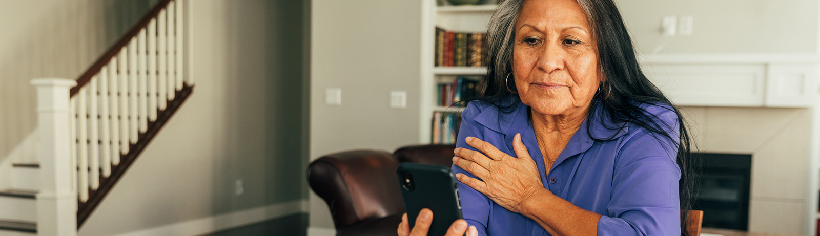 Native American woman using phone in living room