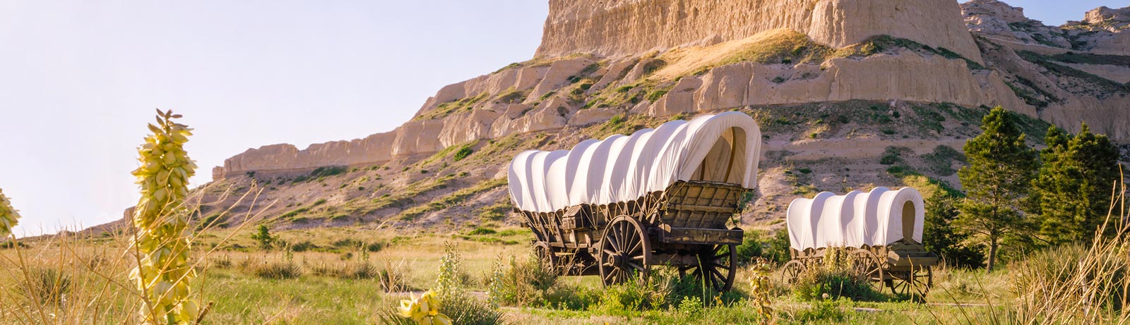 Covered wagons in front of giant rocks in Nebraska