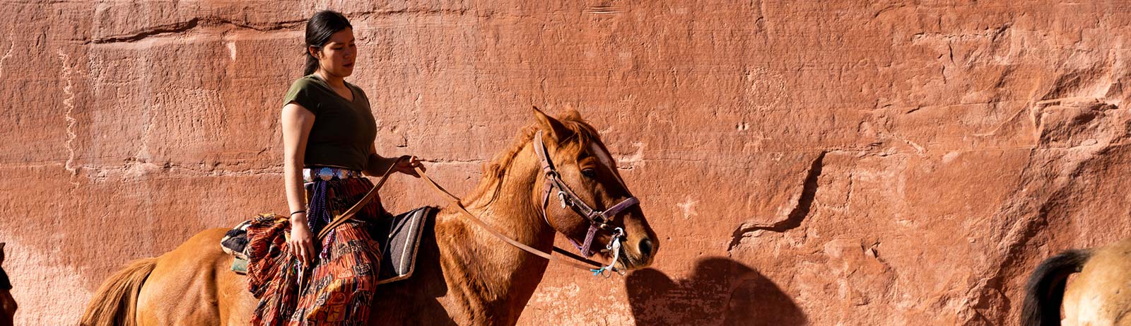 Native American woman riding horse